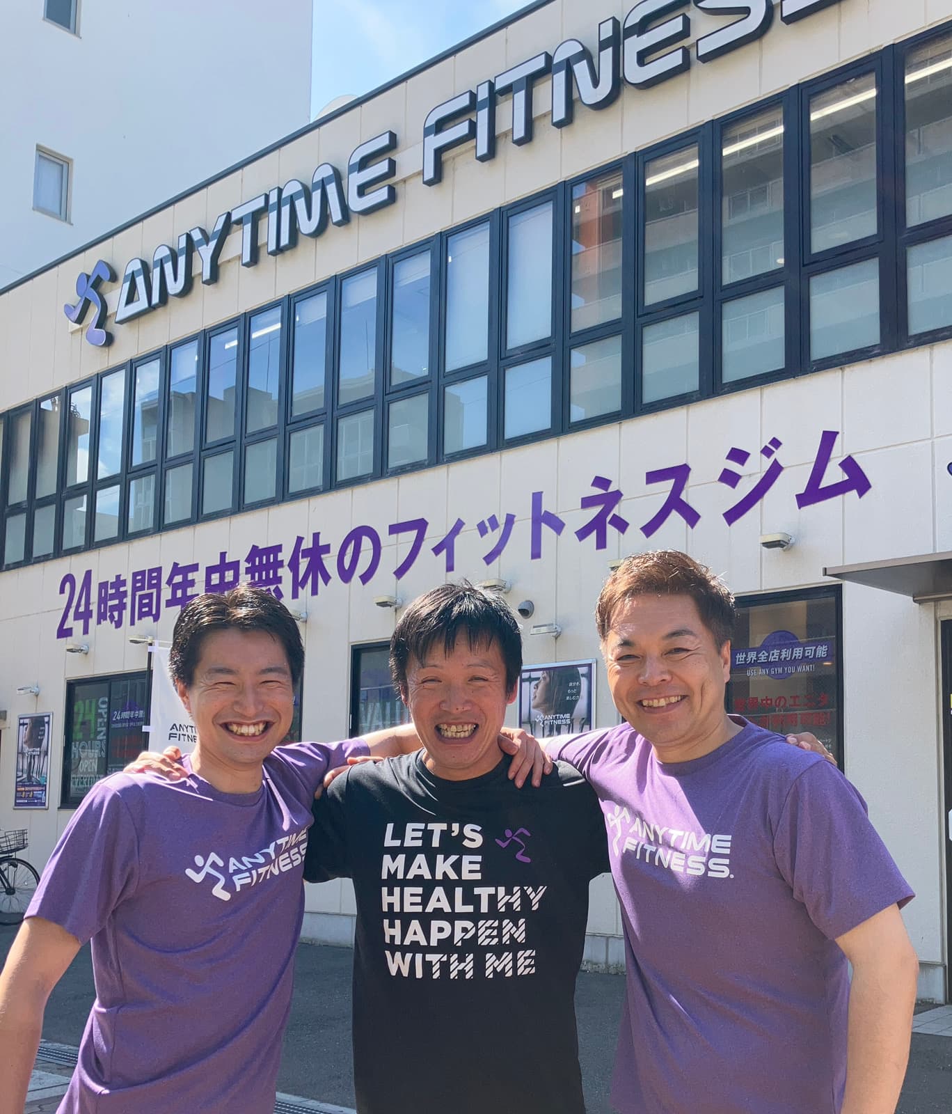 エニタイムフィットネスの店舗前に立つ3名のスタッフ